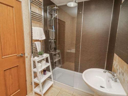 a bathroom with a shower and a sink and a toilet at Home Stead Cottage in Embleton