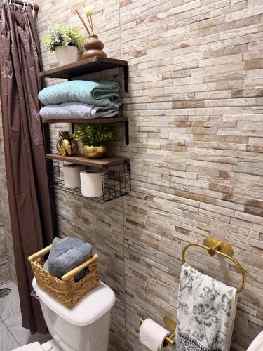 a bathroom with a toilet and towels on a brick wall at Casa Zapata in Chano