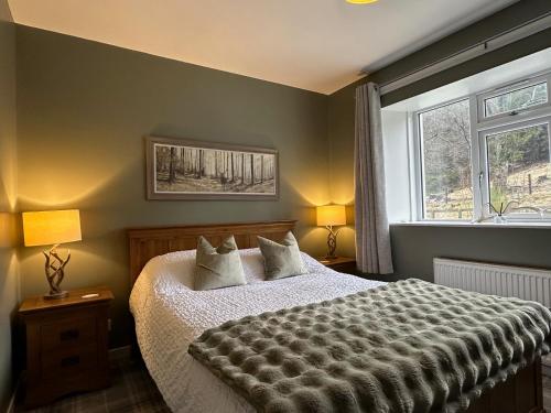 a bedroom with a large bed and a window at White Hillocks Cottage in Inchmill