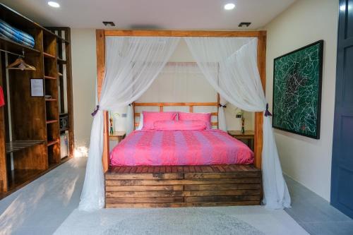 a bedroom with a bed with a canopy at The Longhouse Luxury Boutique Resort in Sakon Nakhon