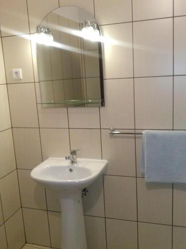 a white bathroom with a sink and a mirror at La Principessa in Oradea