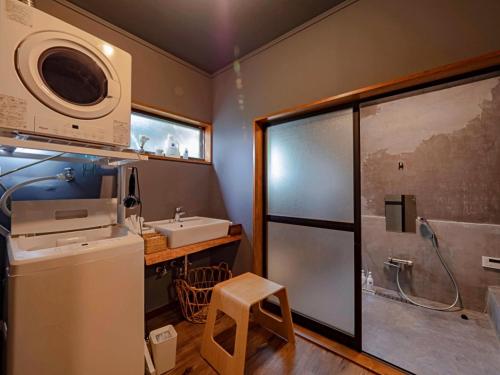 a bathroom with a sink and a shower with a microwave at 古民家宿rootfield in Shōji