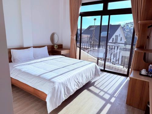 a bedroom with a bed and a large window at The SunHill in Da Lat