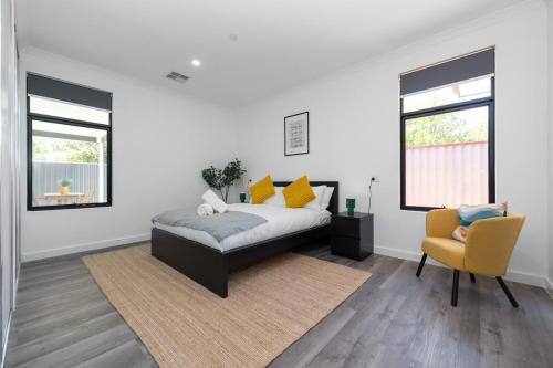 a bedroom with a bed and a yellow chair at Winchester Residence in Armadale