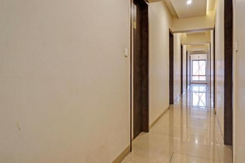 a hallway with white walls and a long hall at Collection O Royce Studios Near Pune Airport in Pune