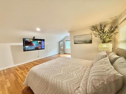 a bedroom with a bed and a flat screen tv at North Haven Rooms in North Haven