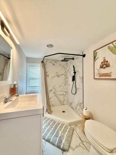 a bathroom with a shower and a toilet and a sink at North Haven Rooms in North Haven