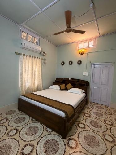 a bedroom with a bed and a ceiling fan at Vina Homestay in Jorhat
