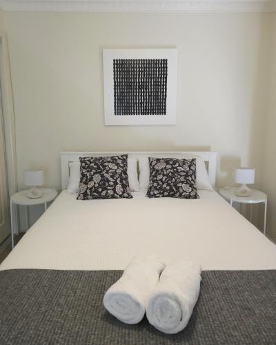 a bed with two pillows and two towels on it at 2-Bedroom Townhouse Next to the Hospital in Bendigo
