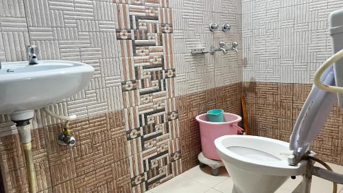 a bathroom with a sink and a toilet at Krishna Holiday Guest House in Dharmsāla