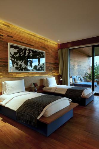 two beds in a hotel room with at Desa Potato Head Bali in Seminyak