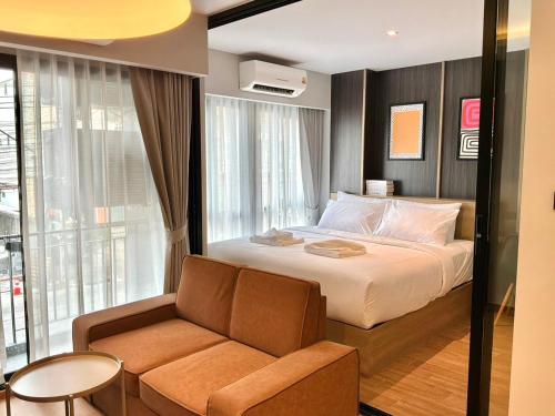 a bedroom with a large bed and a couch at J5 Hotel in Ban Zong Katiam