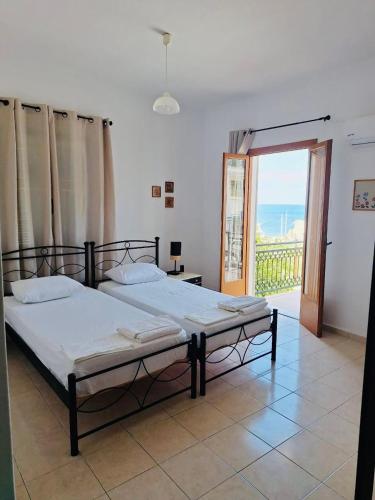 a bedroom with a large bed with a balcony at Nikos Hotel in Diafani