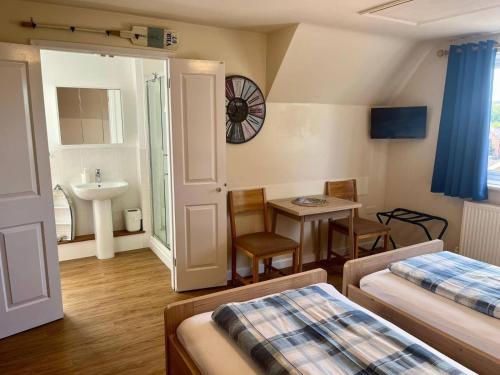 a hotel room with two beds and a sink at Little Bassett Bed & Breakfast in Totland