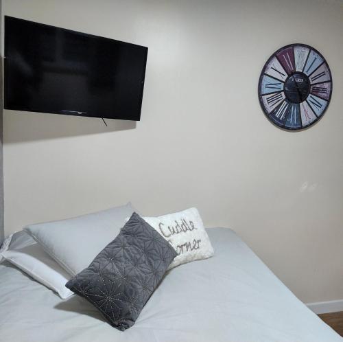 a bed with a pillow and a clock on a wall at Little Bassett Bed & Breakfast in Totland