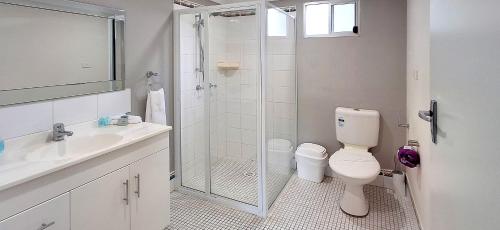 a bathroom with a shower and a toilet and a sink at Sussex Shores in Sussex Inlet