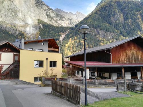 a building with a street light in front of a mountain at Ferienwohnung Mair in Umhausen