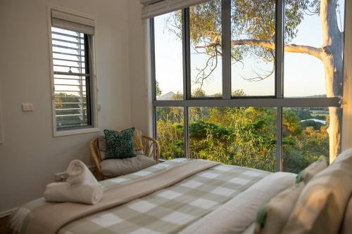 a bedroom with a bed in front of a window at Hinterland Dreamers Poolside Retreat in Yandina Creek