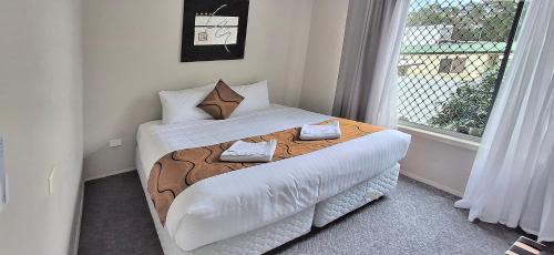 a bedroom with a large bed with a window at Sussex Shores in Sussex Inlet
