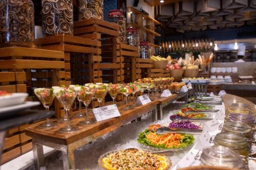 a buffet line with many plates of food and wine glasses at The Soaltee Kathmandu, Autograph Collection in Kathmandu