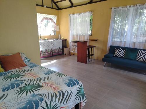 a bedroom with a bed and a table in a room at Happy Monkeys in Puerto Jiménez