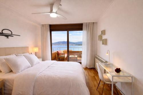 a bedroom with a bed and a view of the ocean at Holibai, Son do mar apto con terraza y vistas a la bahia de Baiona in Baiona