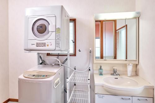 a bathroom with a washing machine and a sink at holidayhouse SERENADE in Nasu