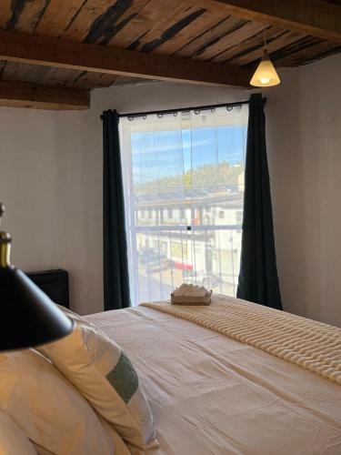ein Schlafzimmer mit einem Bett und einem großen Fenster in der Unterkunft Casa Chepe in Creel