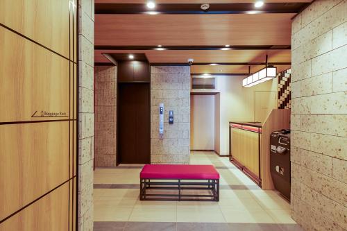 a hallway with a red bench in a room at MONday Apart Nihonbashi Ningyocho in Tokyo