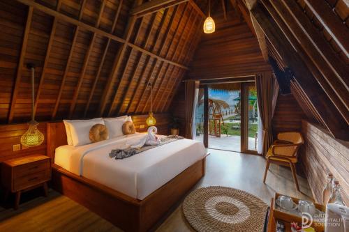 a bedroom with a bed in a room with wooden walls at La Semaya Beach Villas in Nusa Penida
