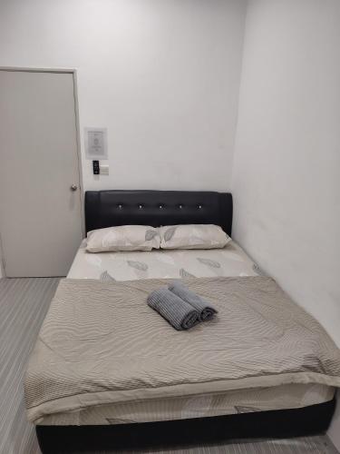 a bed with a pillow on top of it at QA Homestay in Tawau