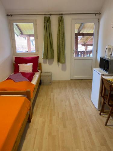 a small room with two beds and a kitchen at Holló Vendégház in Szögliget