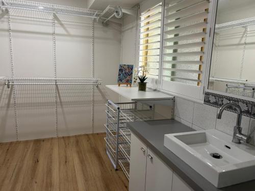 a white kitchen with a sink and a window at South Bunbury Retreat in Bunbury