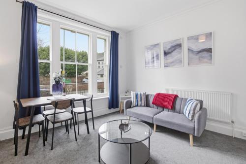 a living room with a couch and a table at Modern Serviced Apartments Steps From Gloucester Quays in Gloucester
