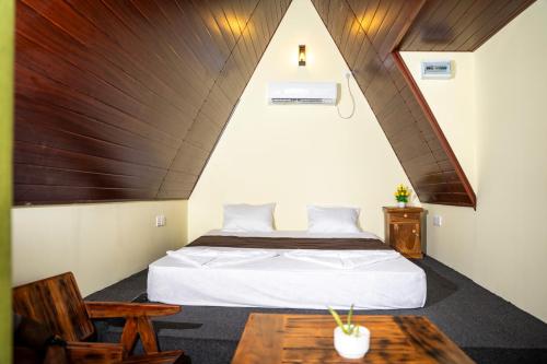 a bedroom with a bed and a wooden ceiling at Nagalakanda Eco Lodge in Millewa