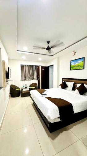 a bedroom with a large bed and a ceiling at Innzoy Comforts - Hitech City Hyderabad in Hyderabad