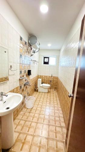 a bathroom with a sink and a toilet at Innzoy Comforts - Hitech City Hyderabad in Hyderabad