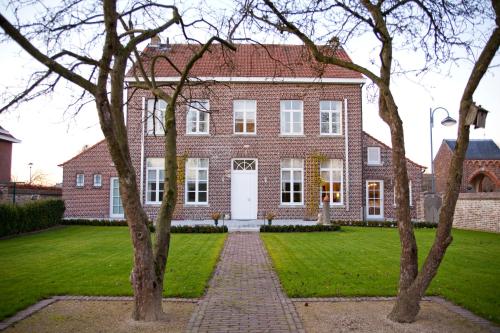 una gran casa de ladrillo rojo con puerta blanca en De Pastory, en Grote-Brogel