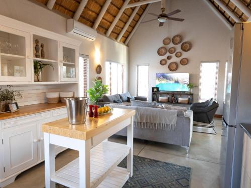 a kitchen and living room with a couch and a table at Ntoma House in Hoedspruit