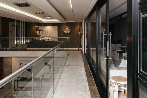 a lobby with glass walls and a staircase in a building at Luxe Life House in Sheffield Beach