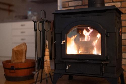 a stove with a fire in it in a kitchen at Lilla nasu in Nasu