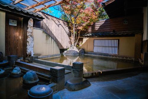 a courtyard with a tree in the middle of a building at Ryokan Kiraku in Beppu