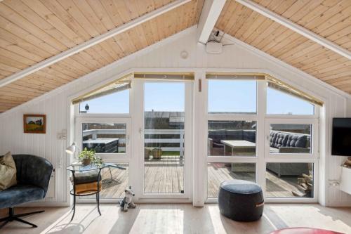 a living room with a large sliding glass door at Summer House With Sauna Near Følle Strand in Rønde