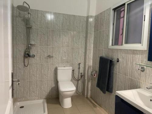 a bathroom with a shower and a toilet and a sink at MySuiteStays Keyless 3Bed Apt in Sacre Coeur in Dakar