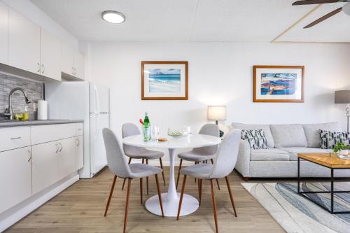 a kitchen and living room with a white table and chairs at Warm Aloha Vibes, Mountain Views, Short Walk to Beach, and Free Parking in Honolulu