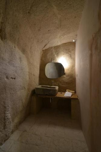 a bathroom with a sink in a stone wall at Le Dimore Dell' Idris in Matera