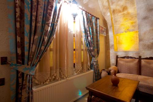 a living room with a couch and a table and curtains at Hikmet's House in Avanos