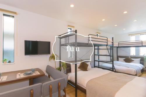 a room with two bunk beds and a tv at fuu in Fukuoka
