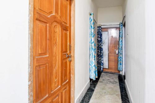 a room with a wooden door and a corridor at HOTEL O RAHAN APPARTMENT in New Town