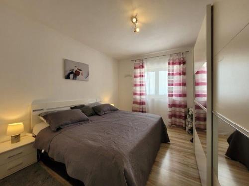 a bedroom with a large bed and a window at Apartment für 4 Personen mit Jacuzzi und Pool in Lovran